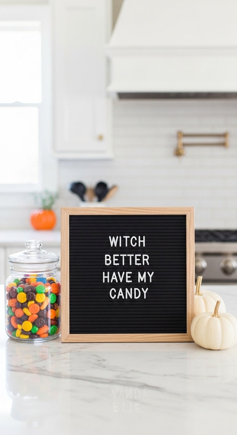 Black felt letter board in a kitchen reads Witch Better Have My Candy with Halloween candy and mini pumpkin