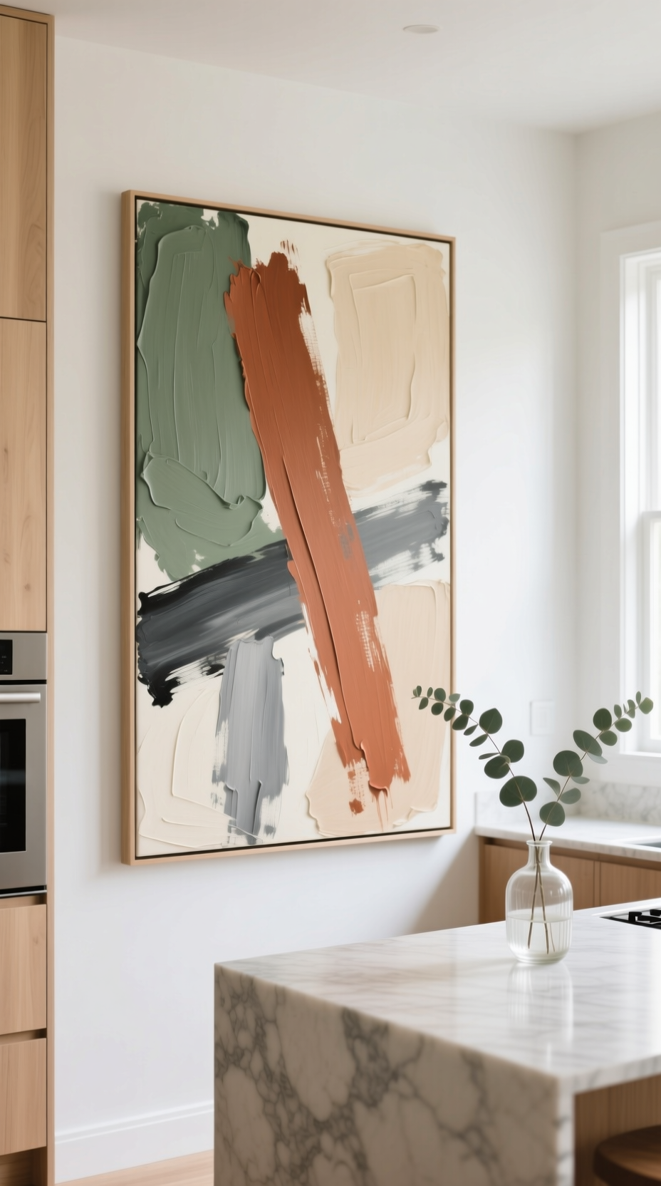 Large abstract canvas art with beige, gray, and terracotta strokes hanging in a modern kitchen with light wood cabinets.