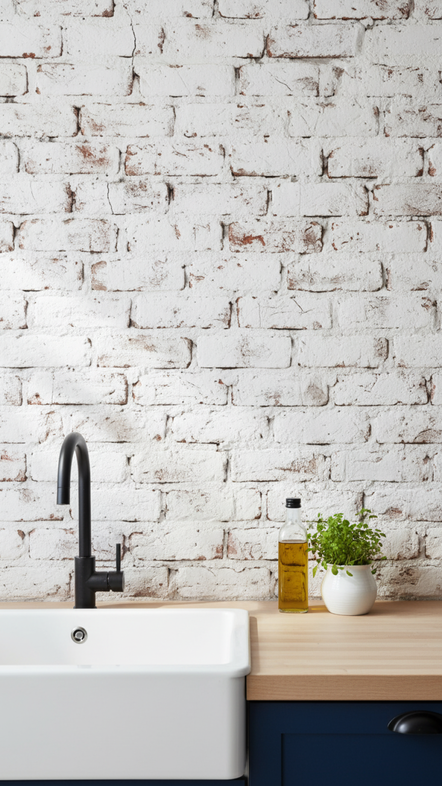 Whitewashed exposed brick backsplash wall with black faucet in industrial Scandi kitchen